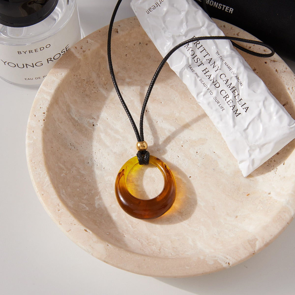 Amber-colored resin long necklace with a black cord. Vera Lux