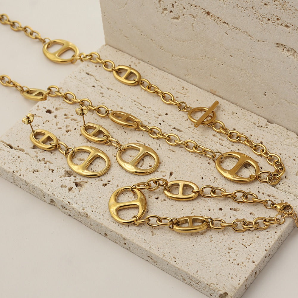 18K gold geometric-shaped necklace, bracelet, and earrings set. Vera Lux